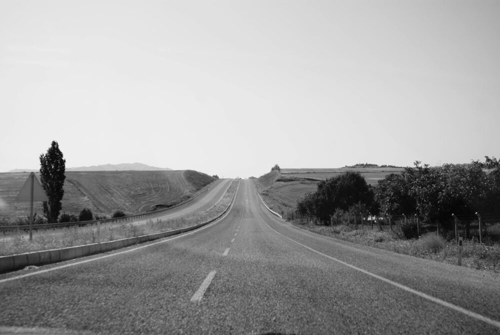 monochrome photo of an empty road